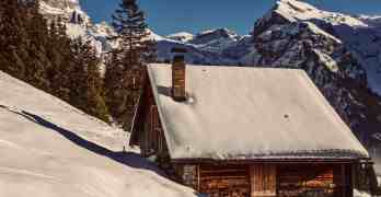 lonely wooden house on snowy mountain slope